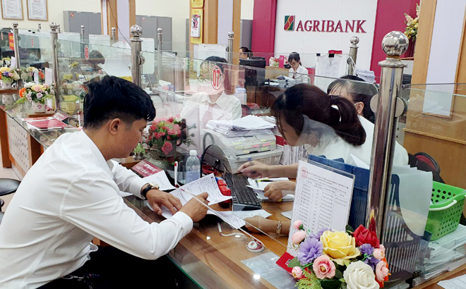 Cán bộ Agribank Chi nhánh huyện Văn Yên Bắc Yên Bái giao dịch với khách hàng. Ảnh: Văn Tuấn